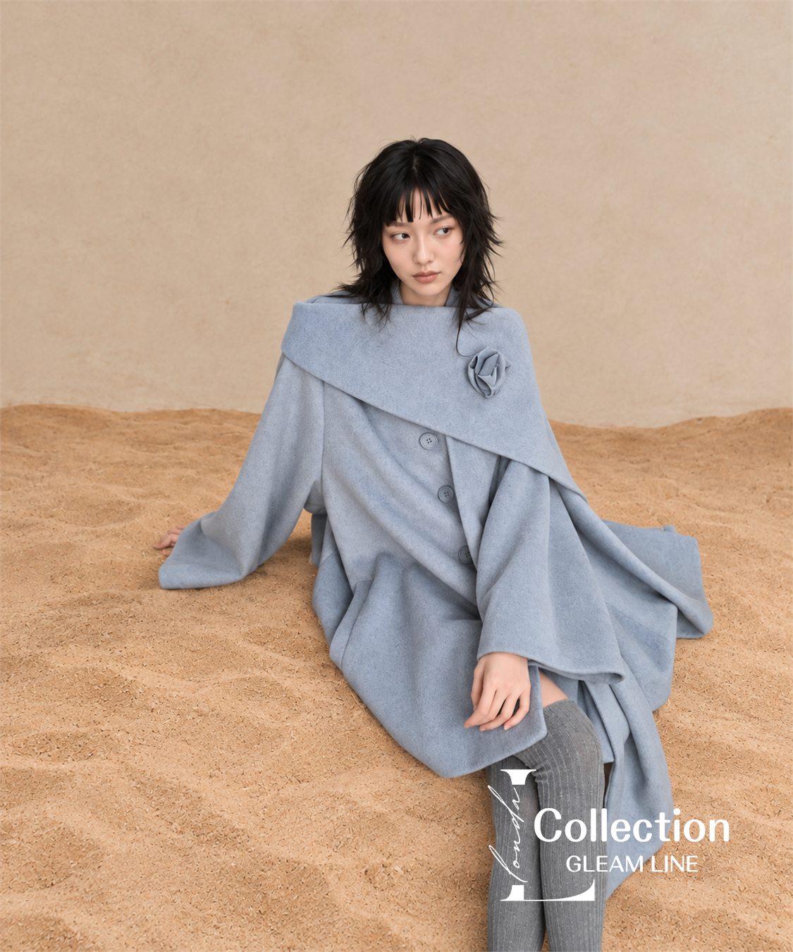 Roselle Scarf Coat — Blue Gray — seated on sand 6